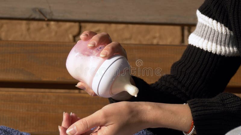 Chiuda su delle mani che controllano il tempreture della formula di bambino fotografia stock libera da diritti Chiuda su delle mani che controllano il tempreture della formula di bambino fotografia stock libera da diritti