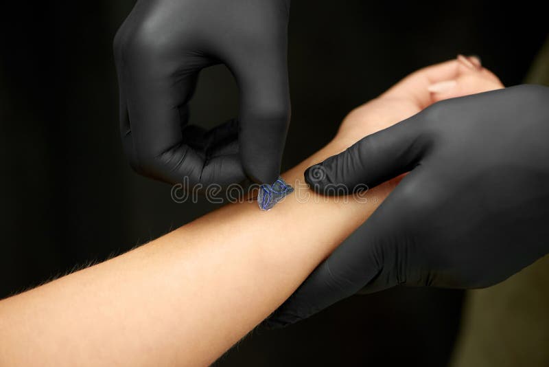 Chiuda su delle mani del padrone che fanno il tatuaggio sulla pelle del cliente fotografia stock libera da diritti Chiuda su delle mani del padrone che fanno il tatuaggio sulla pelle del cliente fotografia stock libera da diritti