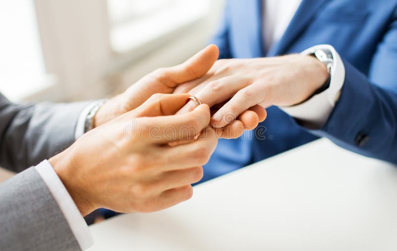 Chiuda su delle mani e della fede nuziale gay maschii delle coppie immagini stock libere da diritti Chiuda su delle mani e della fede nuziale gay maschii delle coppie immagini stock libere da diritti