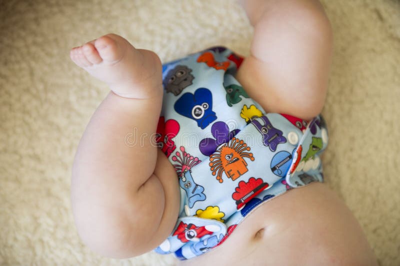 A monster printed reusable cloth nappy on a baby boy. A monster printed reusable cloth nappy on a baby boy