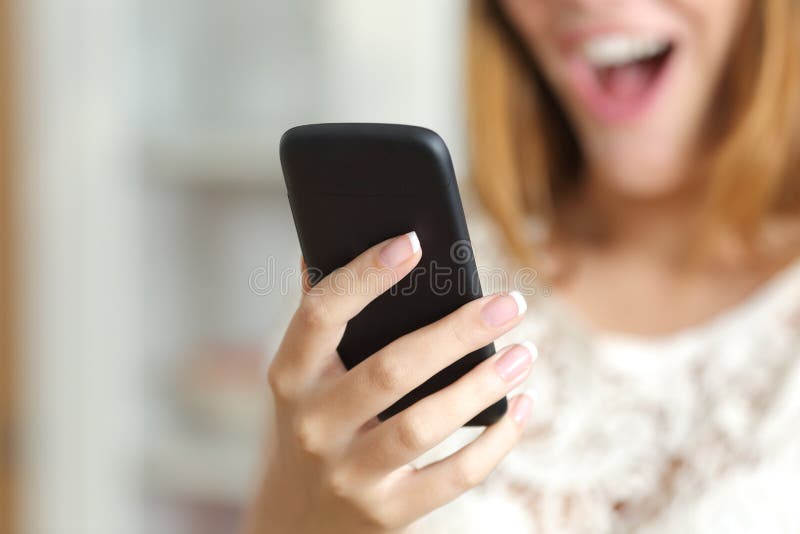 Chiuda su di una donna sorpresa che per mezzo di uno Smart Phone a casa fotografia stock Chiuda su di una donna sorpresa che per mezzo di uno Smart Phone a casa fotografia stock