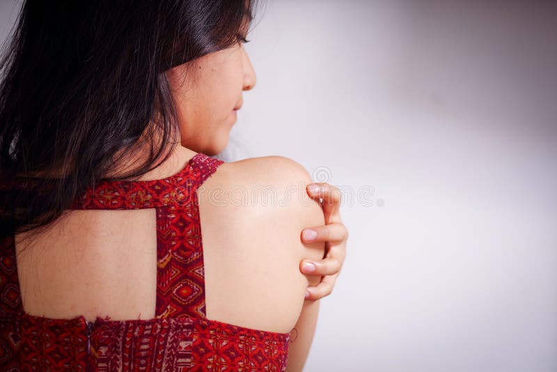 Chiuda su di una giovane donna che graffia la sua spalla con la sua mano dopo la colza e che soffre l'abuso sessuale, in un bianc immagini stock libere da diritti Chiuda su di una giovane donna che graffia la sua spalla con la sua mano dopo la colza e che soffre l'abuso sessuale, in un bianc immagini stock libere da diritti