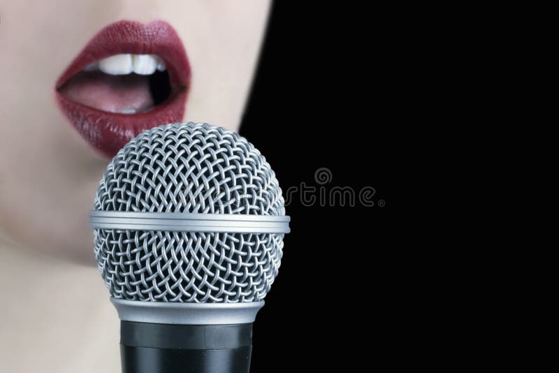 Chiuda su di una giovane donna con le labbra rosse che canta al microphon fotografie stock Chiuda su di una giovane donna con le labbra rosse che canta al microphon fotografie stock