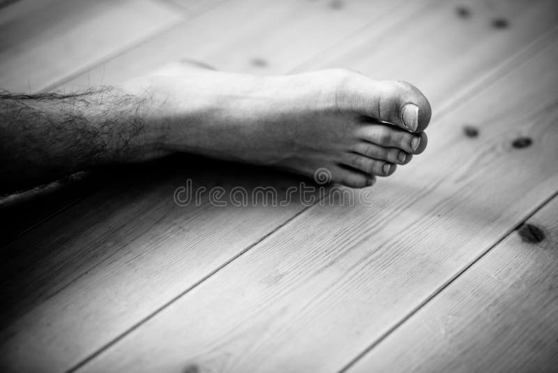 Chiuda su sul piede maschio sopra il pavimento di legno fotografia stock libera da diritti Chiuda su sul piede maschio sopra il pavimento di legno fotografia stock libera da diritti