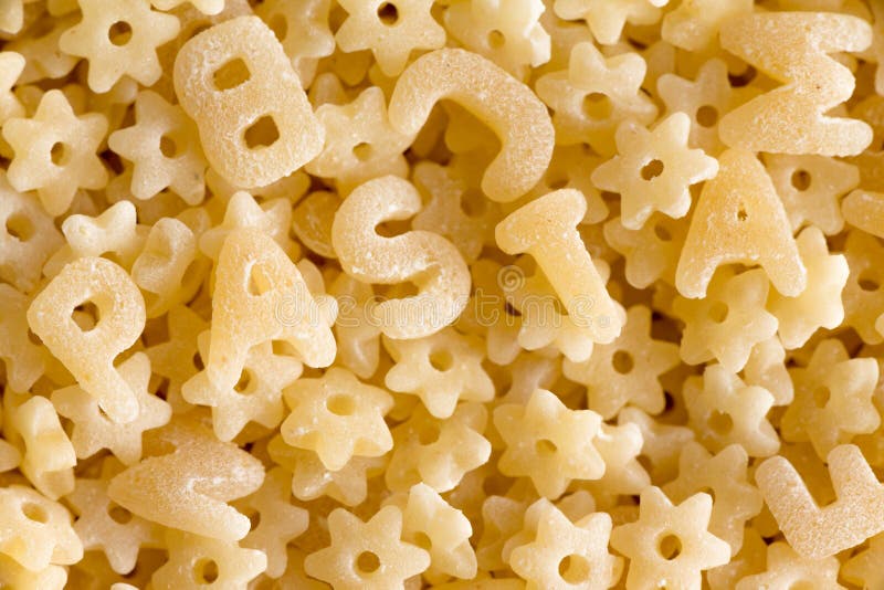 Chiuda su sulla pasta dell'alfabeto che compita la pasta di parola immagini stock Chiuda su sulla pasta dell'alfabeto che compita la pasta di parola immagini stock
