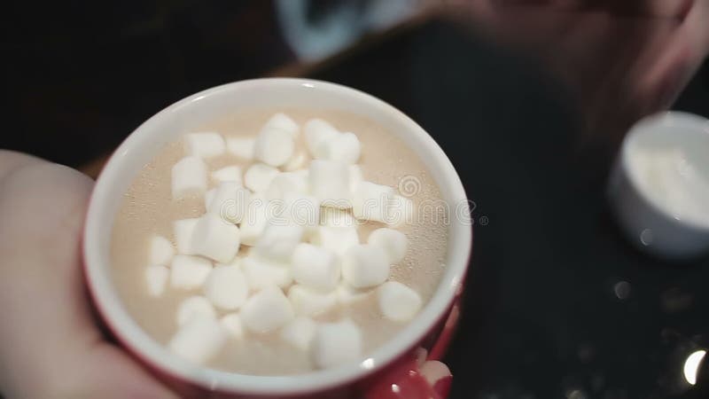 Chiuda sul colpo, le mani di signora con la tazza della bevanda calda che aggiunge i dolci, data romantica archivi video