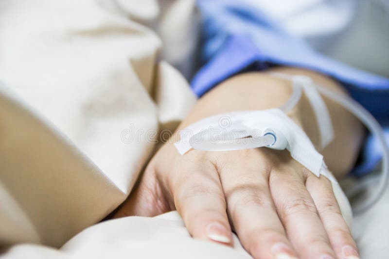 Chiuda sul gocciolamento salino IV per il paziente in ospedale immagini stock libere da diritti Chiuda sul gocciolamento salino IV per il paziente in ospedale immagini stock libere da diritti