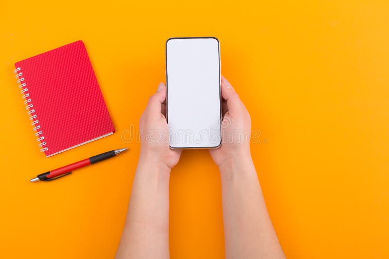 Chiuda sul punto di vista superiore della donna che tiene uno smartphone con lo schermo, il taccuino e la pentola vuoti su fondo fotografie stock Chiuda sul punto di vista superiore della donna che tiene uno smartphone con lo schermo, il taccuino e la pentola vuoti su fondo fotografie stock