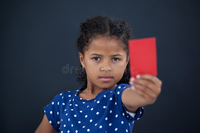 Chiuda sul ritratto della ragazza che mostra il cartellino rosso fotografia stock libera da diritti Chiuda sul ritratto della ragazza che mostra il cartellino rosso fotografia stock libera da diritti
