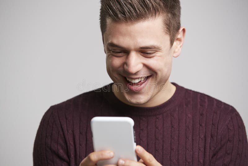 Chiuda sul ritratto di giovane uomo bianco che per mezzo di uno smartphone immagine stock libera da diritti Chiuda sul ritratto di giovane uomo bianco che per mezzo di uno smartphone immagine stock libera da diritti