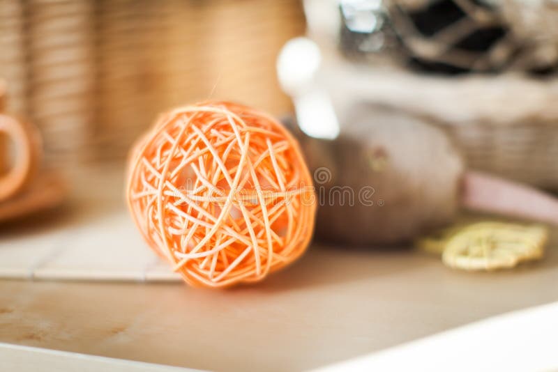 Chiuda sul vimine arancio della palla del rattan sul fondo di legno della tavola con luce solare dalla finestra immagini stock libere da diritti Chiuda sul vimine arancio della palla del rattan sul fondo di legno della tavola con luce solare dalla finestra immagini stock libere da diritti