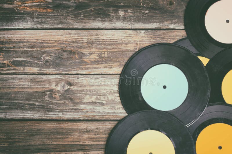 Close up image of old records over wooden table , image is retro filtered. Close up image of old records over wooden table , image is retro filtered