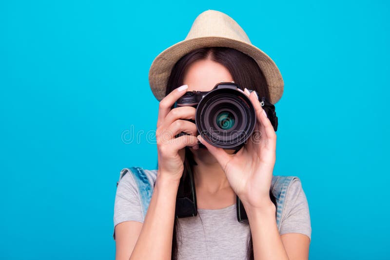 Chiuda sulla foto della donna in cappello su fondo blu che prende una foto immagini stock Chiuda sulla foto della donna in cappello su fondo blu che prende una foto immagini stock