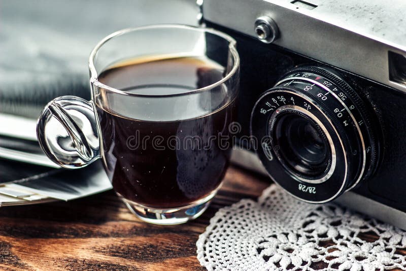 Chiuda sulla foto di vecchio, obiettivo d'annata con il cappuccio di caffè e delle foto in bianco e nero sopra la tavola di legno fotografia stock libera da diritti Chiuda sulla foto di vecchio, obiettivo d'annata con il cappuccio di caffè e delle foto in bianco e nero sopra la tavola di legno fotografia stock libera da diritti