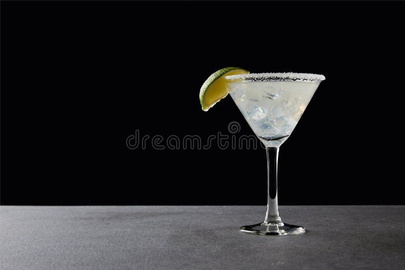 chiuda sulla vista del cocktail saporito della margarita con calce e ghiaccio sul ripiano del tavolo sul nero immagini stock libere da diritti chiuda sulla vista del cocktail saporito della margarita con calce e ghiaccio sul ripiano del tavolo sul nero immagini stock libere da diritti