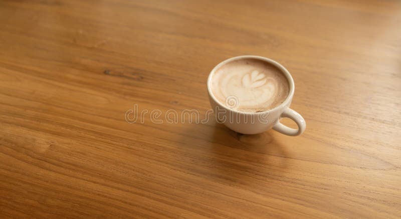 Chiudi di una tazza di caffè, di caffellatte o di un'espresso con tavoletta di legno al mattino per colazione o per pausa Vista d immagini stock