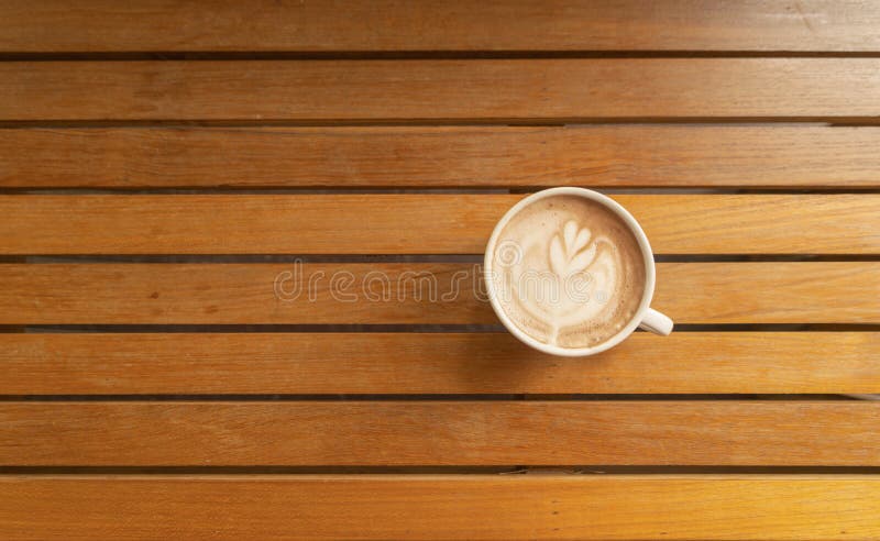Chiudi di una tazza di caffè, di caffellatte o di un'espresso con tavoletta di legno al mattino per colazione o per pausa Vista d fotografie stock