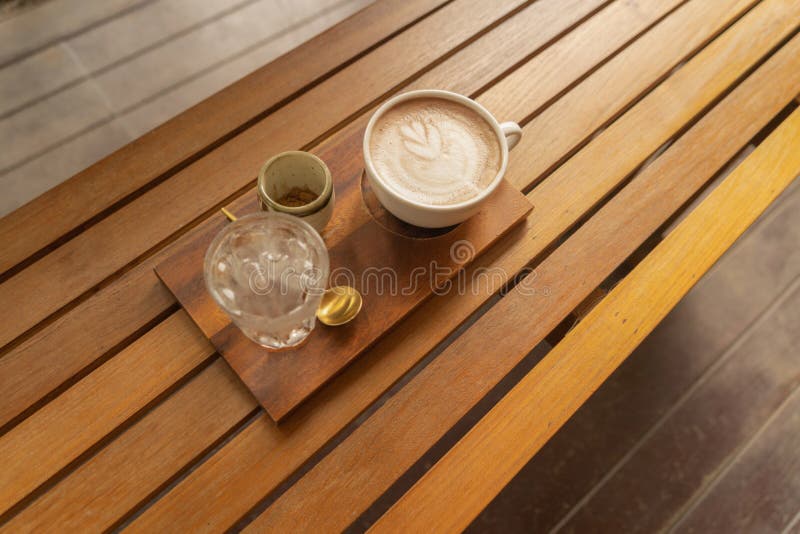 Chiudi di una tazza di caffè, di caffellatte o di un'espresso con tavoletta di legno al mattino per colazione o per pausa Vista d fotografie stock libere da diritti