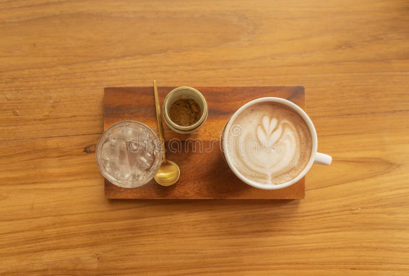 Chiudi di una tazza di caffè, di caffellatte o di un'espresso con tavoletta di legno al mattino per colazione o per pausa Vista d fotografia stock libera da diritti