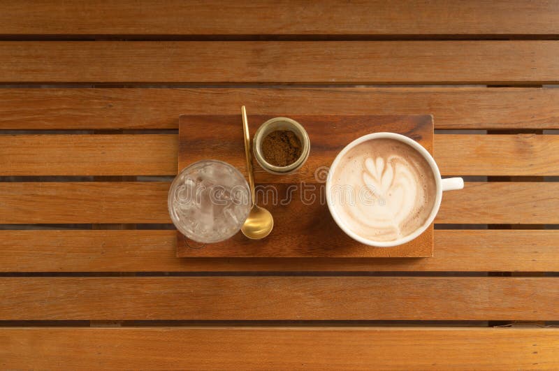 Chiudi di una tazza di caffè, di caffellatte o di un'espresso con tavoletta di legno al mattino per colazione o per pausa Vista d fotografia stock