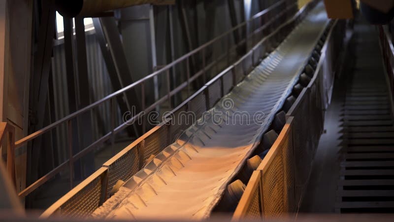 Close up of conveyor belt with white cloth. Industrial background inside the workshop of the factory and moving conveyor belt with narrow stripe of white fabric. Close up of conveyor belt with white cloth. Industrial background inside the workshop of the factory and moving conveyor belt with narrow stripe of white fabric.