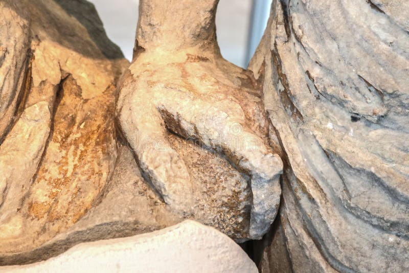 Chiusura dell'antica scultura greca con mano rotta tra due torsodi intagliati immagini stock libere da diritti Chiusura dell'antica scultura greca con mano rotta tra due torsodi intagliati immagini stock libere da diritti