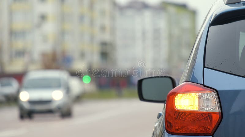 Chiusura della luce posteriore di un'auto rotta parcheggiata sul lato della strada della città con luci lampeggianti.