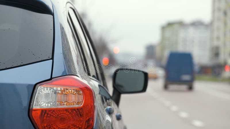 Chiusura della luce posteriore di un'auto rotta parcheggiata sul lato della strada della città con luci lampeggianti.