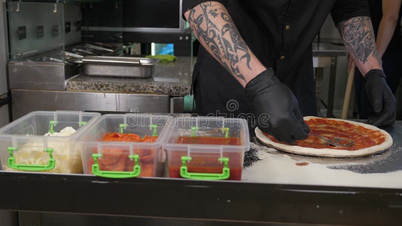 Chiusura della salsa di pomodoro in cucchiaino sulla pasta per pizza in pizzeria. archivi video