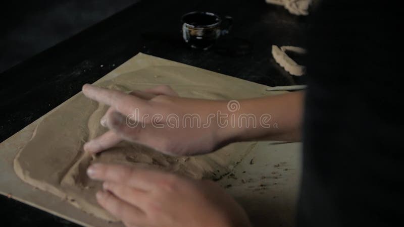 Chiusura delle mani dei bambini che scolpiscono un cavallo dalla modellazione dell'argilla in un laboratorio.