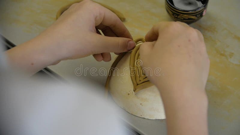 Chiusura delle mani dei bambini scolpendo l'argilla da modellazione in un laboratorio.