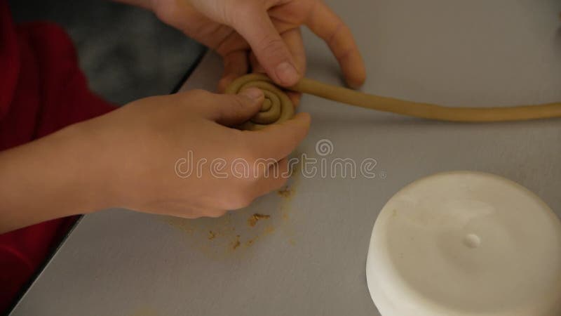 Chiusura delle mani dei bambini scolpendo l'argilla da modellazione.
