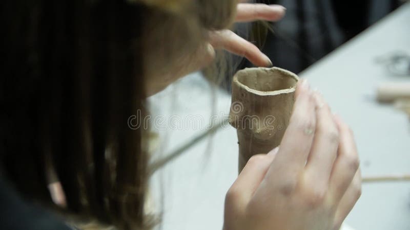 Chiusura delle mani dei bambini scolpendo l'argilla da modellazione in un laboratorio.