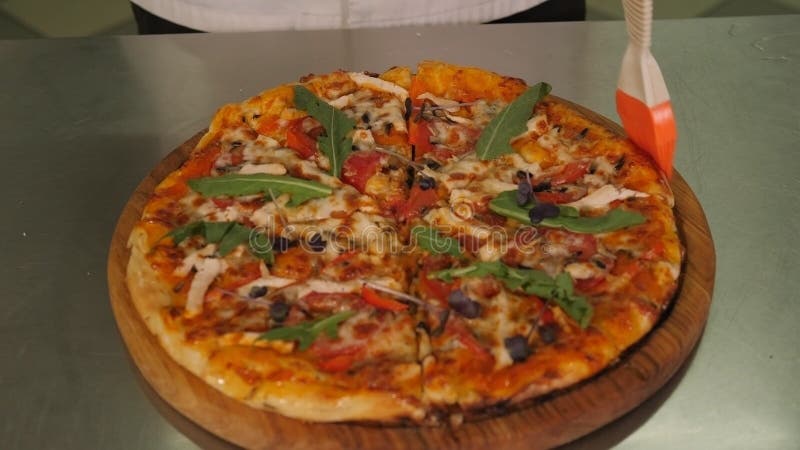 Chiusura dello chef che ingoia una pizza appena cotta con olio prima di servire la pizzeria