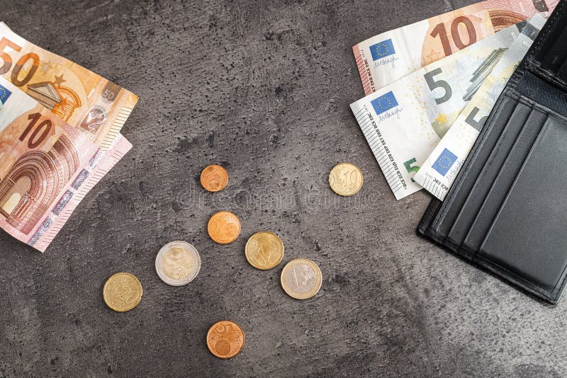 Chiusura di banconote monete e portafoglio nero. euro su fondo nero