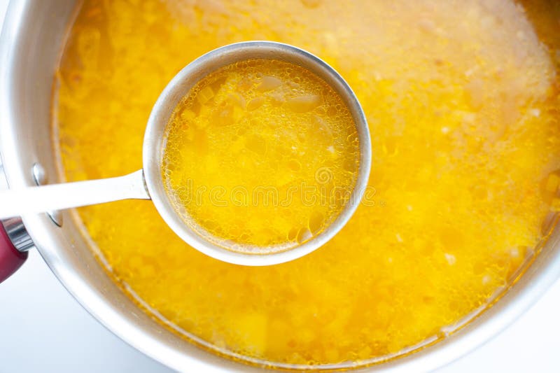 Closeup of broth, clear soup or bouillon in a saucepan. Closeup of broth, clear soup or bouillon in a saucepan