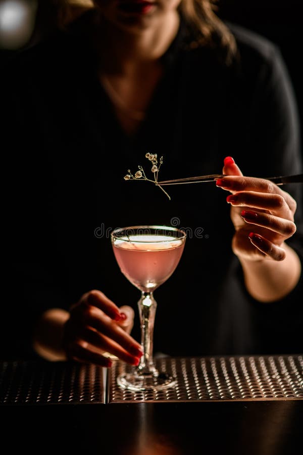 Chiusura di fioritura con cui la donna addobba il vetro con cocktail immagini stock libere da diritti