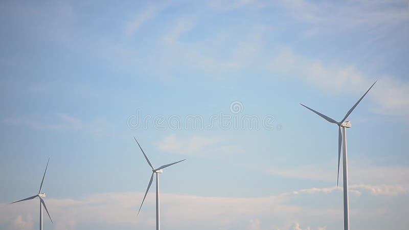 Chiusura di turbine eoliche o di convertitori di energia eolica in giornata di sole con cielo azzurro e nuvole bianche produzione