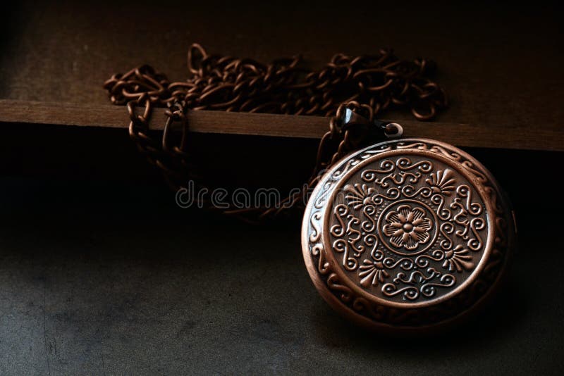 Closeup copper locket with chain with dark background. Closeup copper locket with chain with dark background