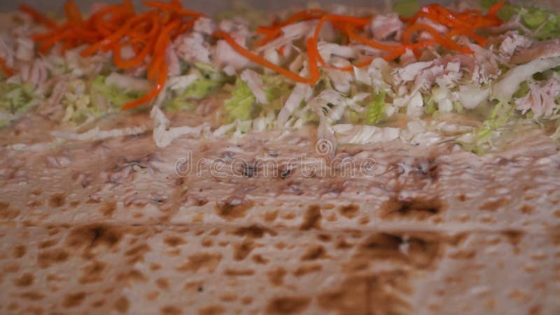 Chiusura di un processo di cottura della shawerma. la torta è riempita di salsa e carote. archivi video