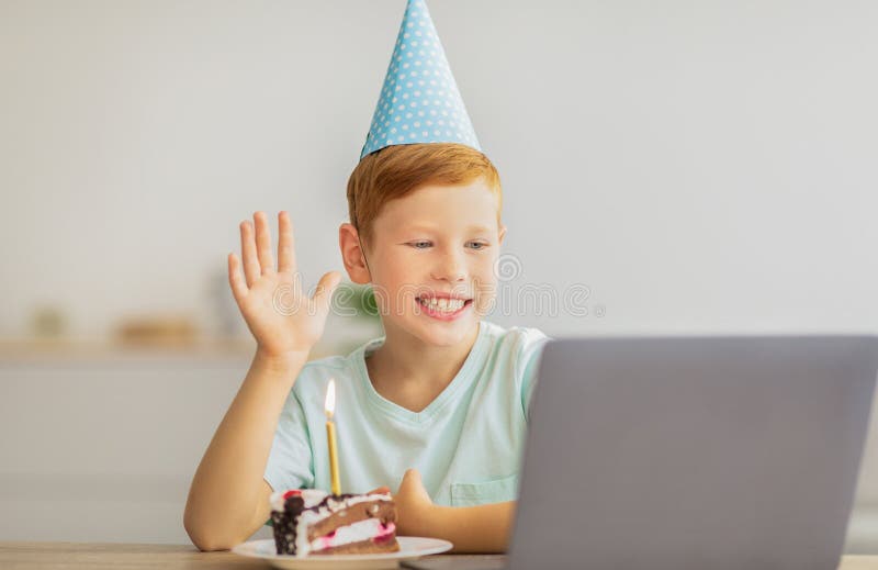 Chiusura di un ragazzo alla festa che partecipa alla festa di compleanno online immagini stock