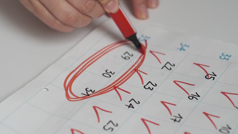 Chiusura manuale femmina disegna un numero di marcatore rosso sul calendario. data nel concetto di anno stock footage