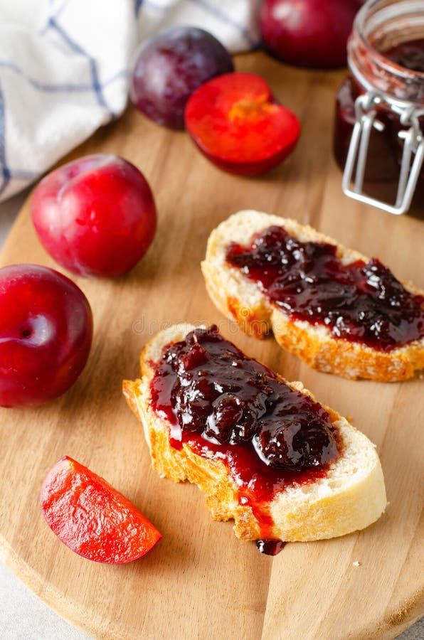 Chlebowe toasty z śliwkowym dżemem pyszne domowy dżem śliwkowy na jasnym tle.