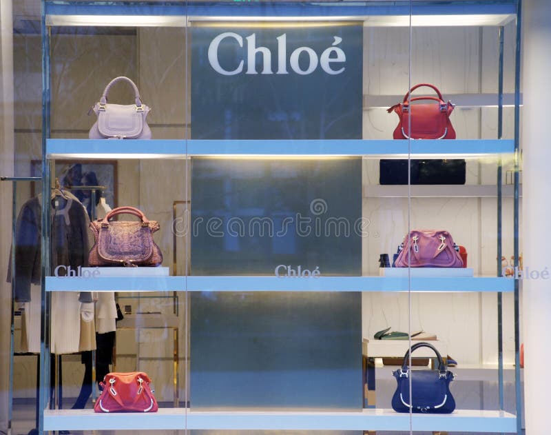 Shanghai/China-July 2019: close up bright shining Chloe logo on dark  exterior wall at night. Blurred store windows behind. Famous French fashion  luxury brand Stock Photo