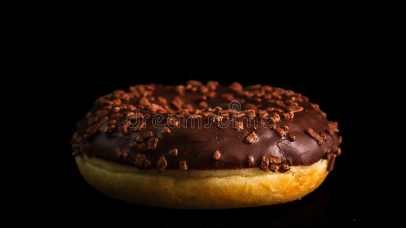 Chocoladeglazuurde donut met chocoladechips, geïsoleerd. Close-up van een heerlijke donut royalty-vrije stock afbeeldingen