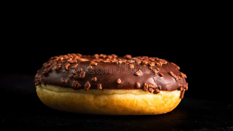Chocoladeglazuurde donut met chocoladechips, geïsoleerd. Close-up van een heerlijke donut royalty-vrije stock afbeeldingen