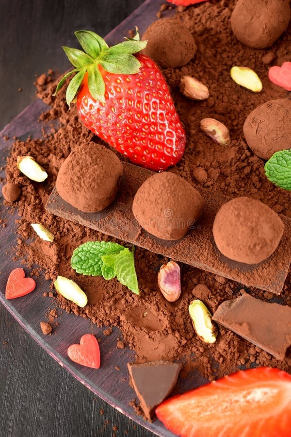 Chocoladetruffels door aardbeien en munt worden omringd die royalty-vrije stock afbeeldingen Chocoladetruffels door aardbeien en munt worden omringd die royalty-vrije stock afbeeldingen