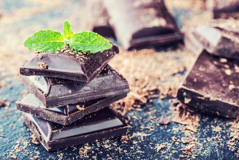 Chocolat Chocolat noir Quelques cubes de chocolat noir avec les feuilles en bon état photos libres de droits Chocolat Chocolat noir Quelques cubes de chocolat noir avec les feuilles en bon état photos libres de droits