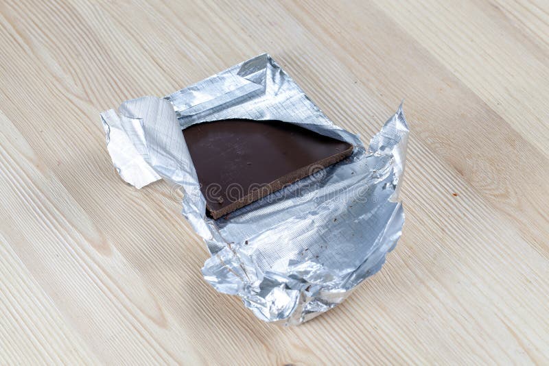 a chocolate bar open from foil on a white table