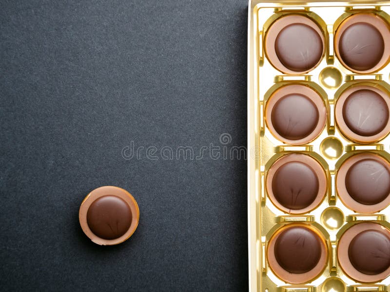 Chocolate candies in a gold box over black background, top view royalty free stock image Chocolate candies in a gold box over black background, top view royalty free stock image